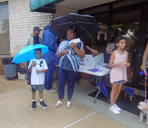 Ryan Mitchell and mom Regina keep dry while eating ice cream. He said the best part of the evening is "the police and meeting the mayor."