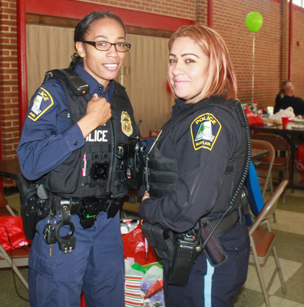 Officers Konetta Brown (left) and Yomayra Rodriguez had a great time helping kids shop for their families.  Photo by George Mathews