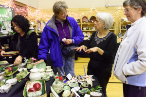 Lola Skolnik shows her pottery to a visitor - Photo by Eric Zhang