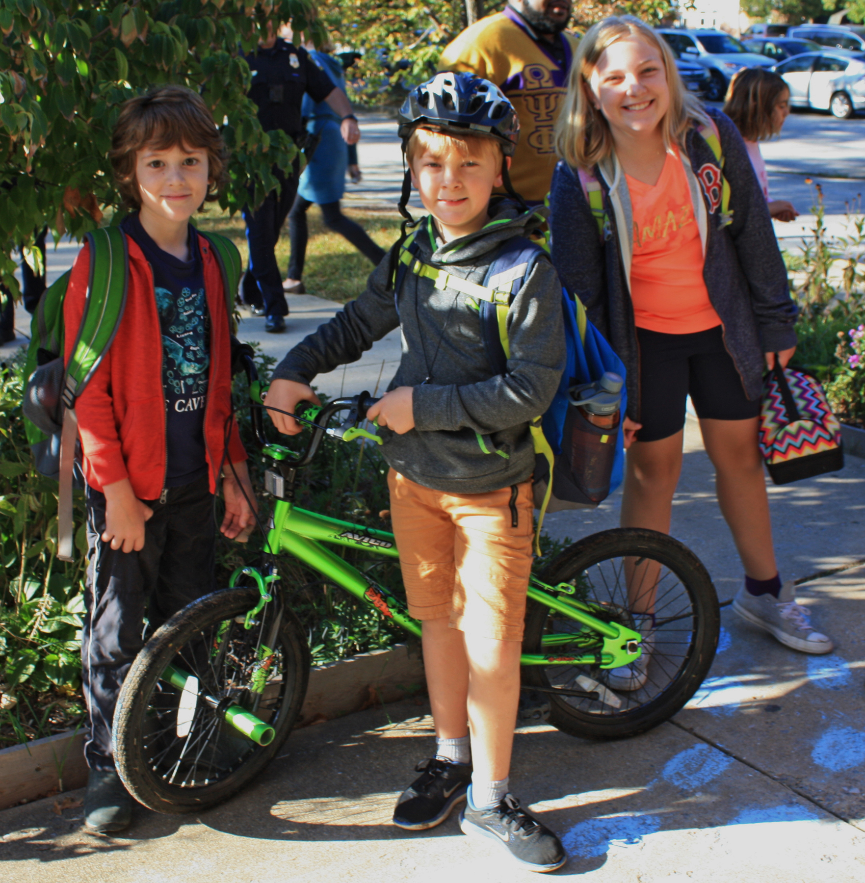 Three kids from Greenbelt Elementary School walk with thier bikes. Photo by George Mathews