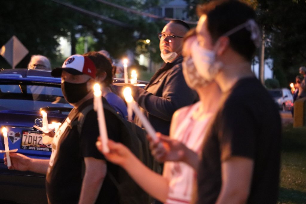 Greenbelt residents hold candles in a vigil along Greenbelt Road.