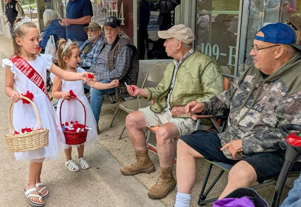 children distribute poppy flowers
