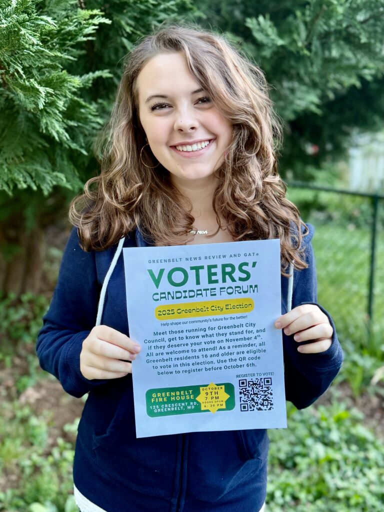 A light-skinned teenage girl with curly shoulder-length light brown hair, wearing a blue shirt. She holds a flyer with the words VOTERS' CANDIDATE FORUM in green text, and other text too small to read. A QR code is visible in the lower corner. She is standing in front of a tree.
